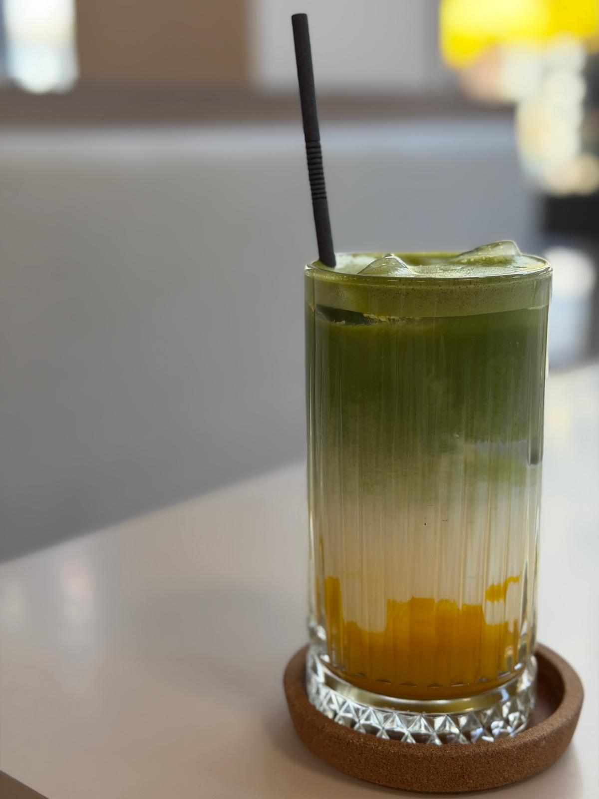 Geschichteter Matcha-Mango-Latte im Glas